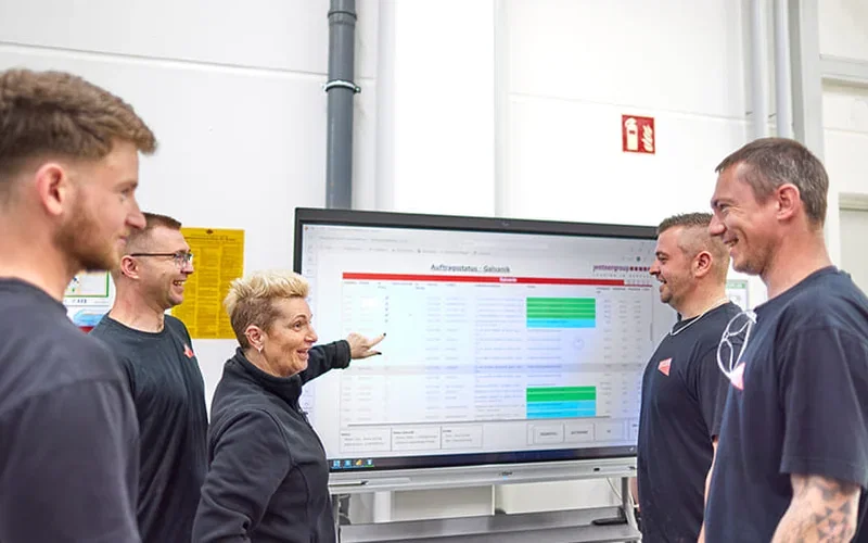 Team der C. Jentner GmbH vor dem Monitoring-Board von Jentner AI in der Produktion